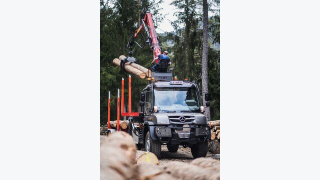 Unimog im Holzeinsatz mit Ladekran und Rungenauflieger