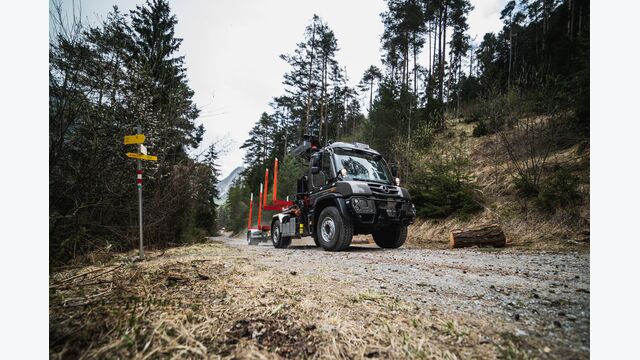 U 530 Unimog im Wald auf einer Forststraße mit Rungenanhänger