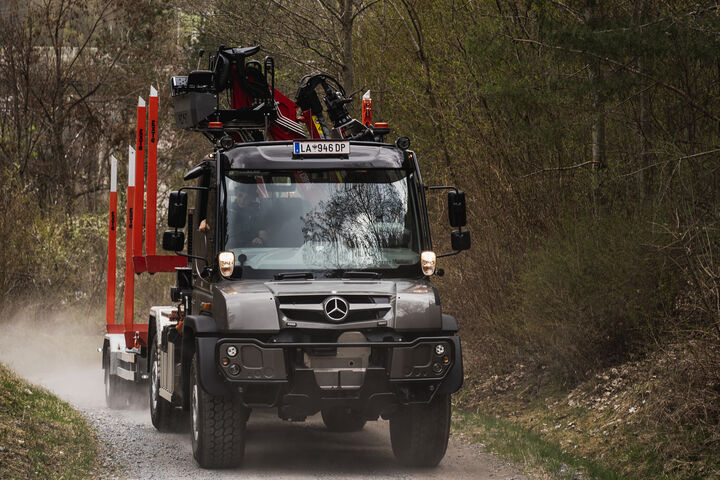 Unimog U 530 auf einer Forststraße mit Rungenanhänger für die Holztransport
