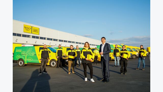E-Fahrzeuge der Post mit Personal vor der Zustellbasis