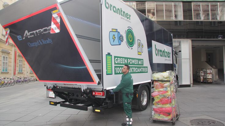 Der Lkw wird beladen, die Hebebühne dazu abgesenkt, daneben steht ein Transportwagen mit Behältern