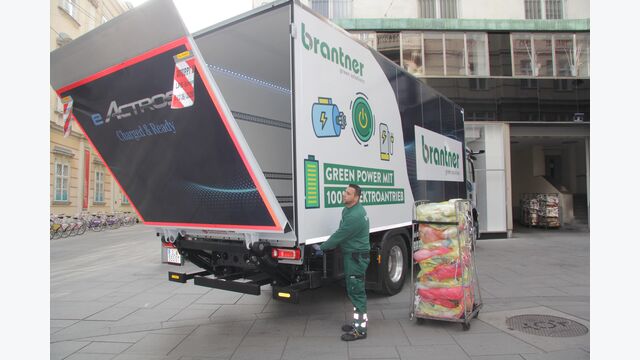 Der Lkw wird beladen, die Hebebühne dazu abgesenkt, daneben steht ein Transportwagen mit Behältern