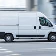 Moscow, Russia - August 2021: White Fiat Ducato cargo van with tall roof is driving on the street, side view. Light commercial vehicle in motion