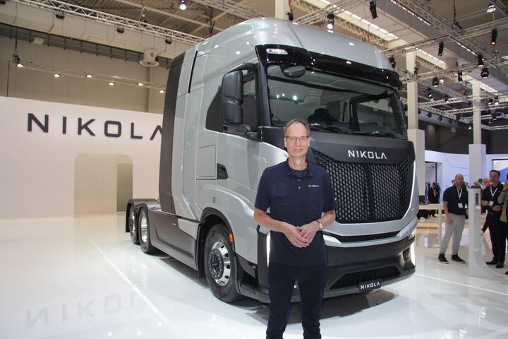 Michael Lohscheller im Portrait vor einem Nikola Lkw Prototyp auf der IAA Transportation 2022 in Hannover