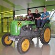 elektrifizierter 18er-Steyr-Traktor im Foyer der HTL St.Pölten. Schüler sitzen darauf, Lehrer steht daneben
