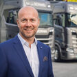 Robert Techler im Portrait vor Scania-Lastwagen