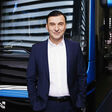 Barbaros Oktay, Head of Bus, MAN Truck & Bus SE, vor einem MAN Bus, mit Händen in den Hosentaschen