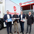 Transgourmet und Renault Personal vor einem E-Truck mit Filiale im Hinterngrund