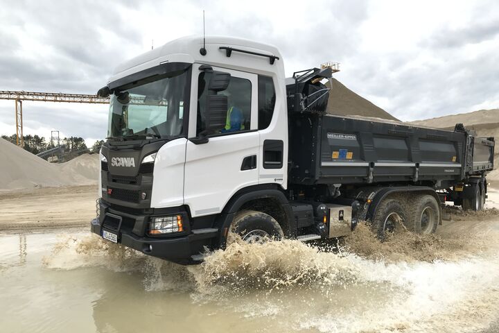 Scania-Lkw fährt durch eine Wasser-Pfütze