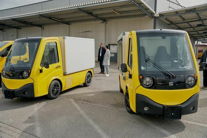 Zwei Testfahrzeuge von Sevic auf einem Parkplatz in Post AG Farben ohne Kennzeichen.