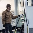 Ein Mann steckt einen Elektro-Lkw zum Laden mit Strom an