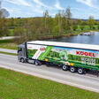 Lkw mit Kögel Auflieger auf der Straße mit Teich im Hintergrund.