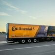 Gelber Lkw vor einem Sonnenaufgang mit Continental Überschrift am Auflieger.