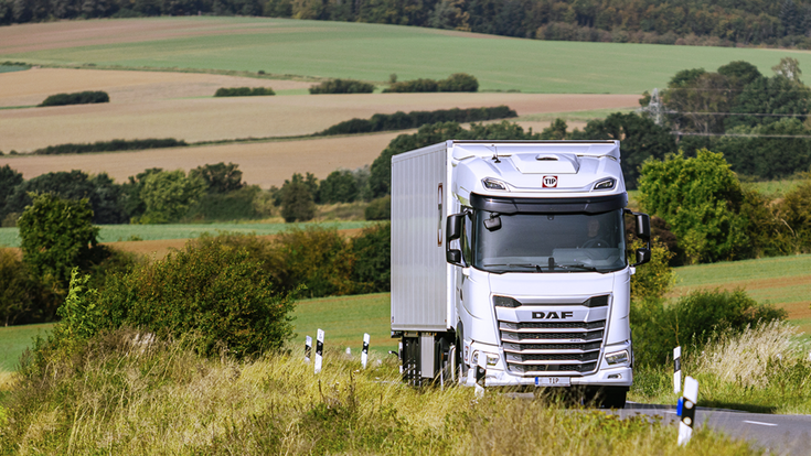 © Tip Trailer weißer DAF Truck, im Hintergrund Wald und Wiesen