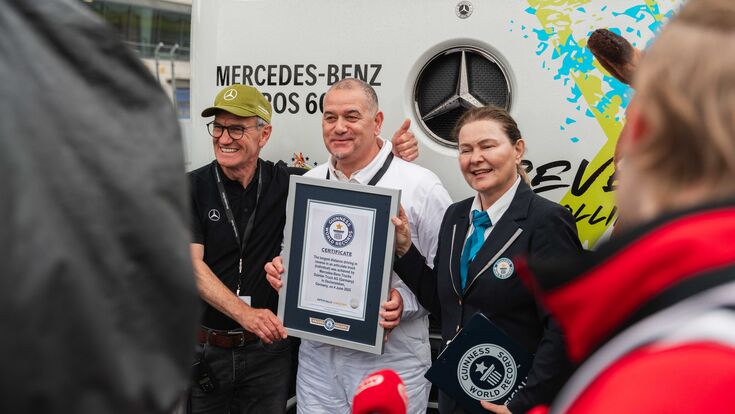 Guinness World Records-Titel für die längste rückwärtsgefahrene Strecke mit einem Sattelzug (Einzelperson). Marco Hellgrewe (Mitte) und Werner Kempfle, Entwicklungsingenieur und Co-Projektleiter des eActros 600, nehmen die Auszeichnung von Seyda Subasi-Gemici, Jurorin, Guinness World Records Limited, entgegen.